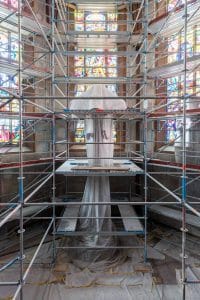 Interieurfotografie - Hauptchor mit eingehülltem Kruzifix des Niclaus Gerhaert van Leyden, umgeben von Malergerüst während der Sanierung der Stiftskirche in Baden-Baden.