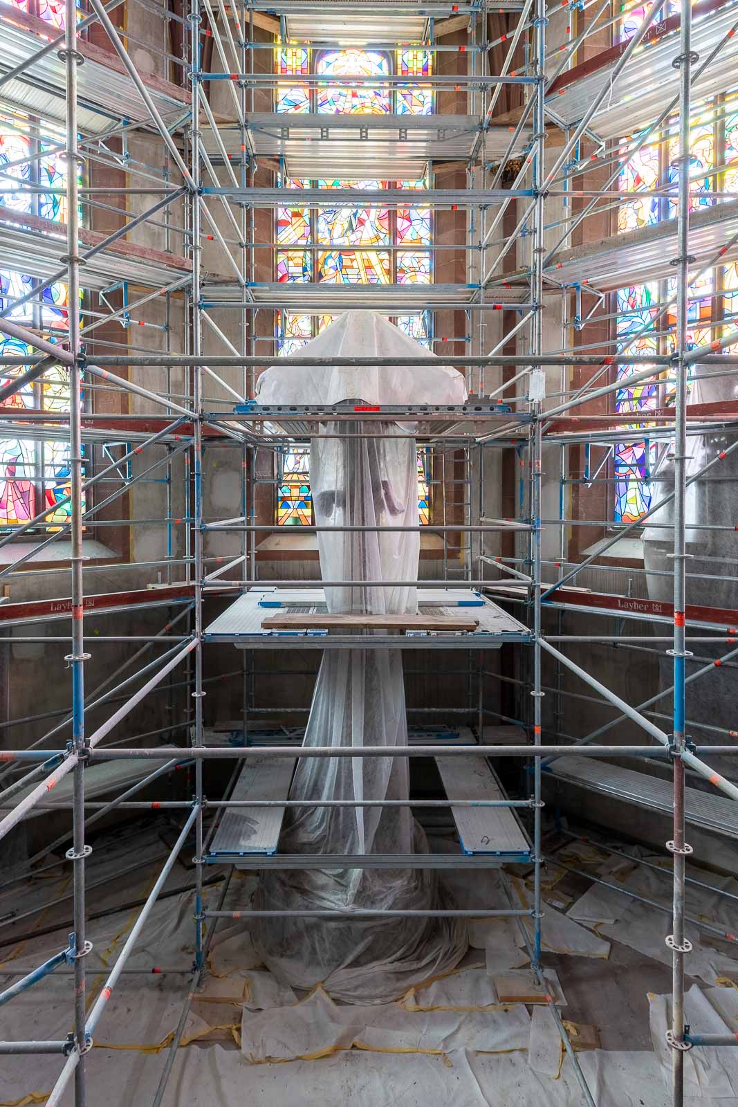 Interieurfotografie - Hauptchor mit eingehülltem Kruzifix des Niclaus Gerhaert van Leyden, umgeben von Malergerüst während der Sanierung der Stiftskirche in Baden-Baden.