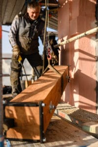 Montage eines Holzbalkens als Glockenträger auf einem Kirchturm