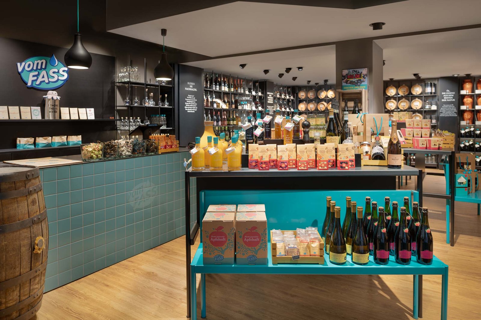 Innenaufnahme des "vom FASS"-Geschäfts in Baden-Baden mit stilvoller Produktpräsentation von Spirituosen, Ölen und Essigen in hochwertigem Ladenbau.