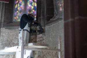 Handwerker beim Abklopfen von Putz in der Stiftskirche Baden-Baden
