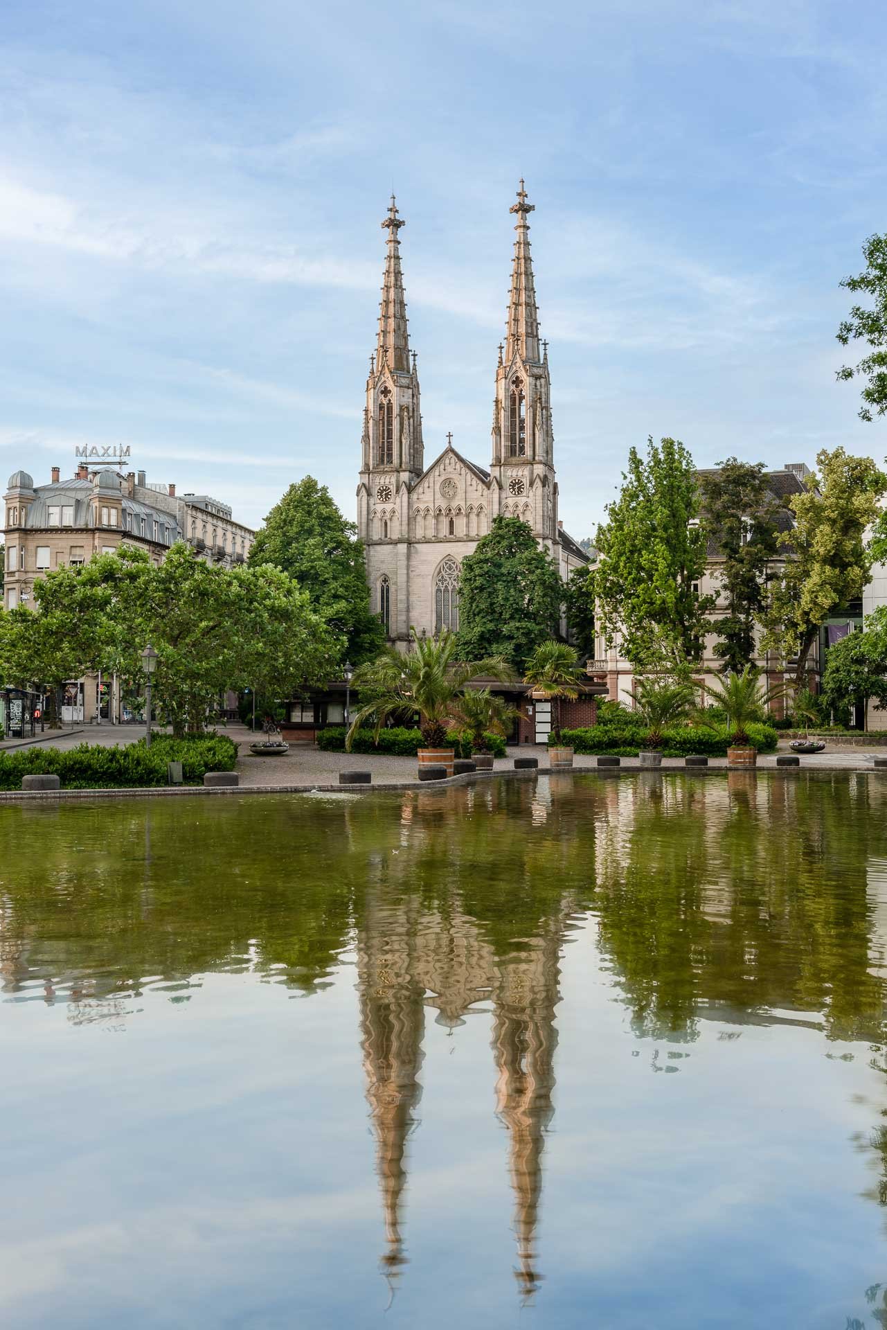 Evangelische Stadtkirche Baden-Baden mit Spiegelung im Brunnen am Augustaplatz