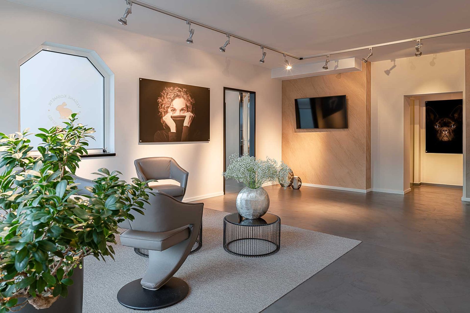 Moderner Wartebereich mit stilvollen Sesseln, Kunstwerken und Pflanzen bei Baden Beauty in Baden-Baden.